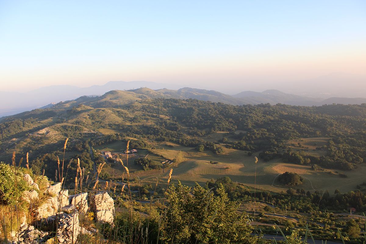 Wooded hills and pastures of the Monti Prenestini at dusk, seen from a rocky outcrop